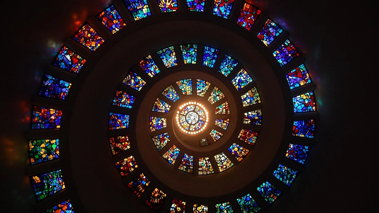 Une rosace de vitraux vue depuis le sol, ses compartiments en spirale