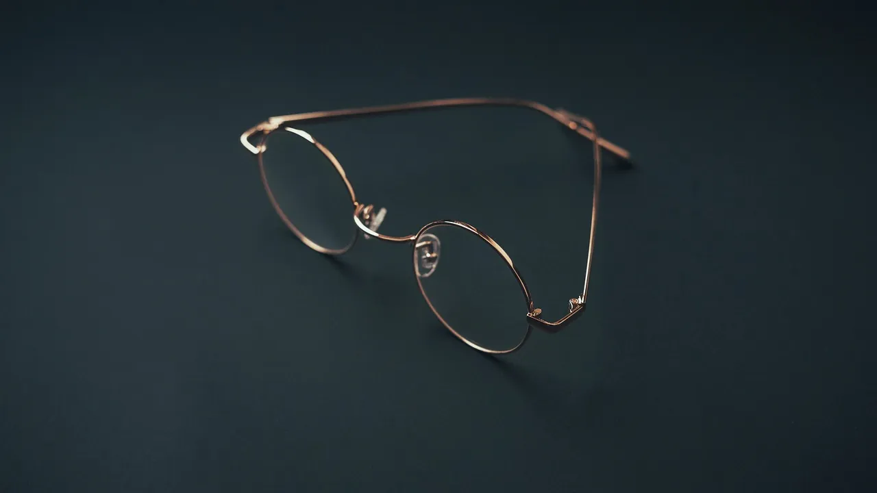 Une paire de lunettes rondes à monture fine sur fond sombre